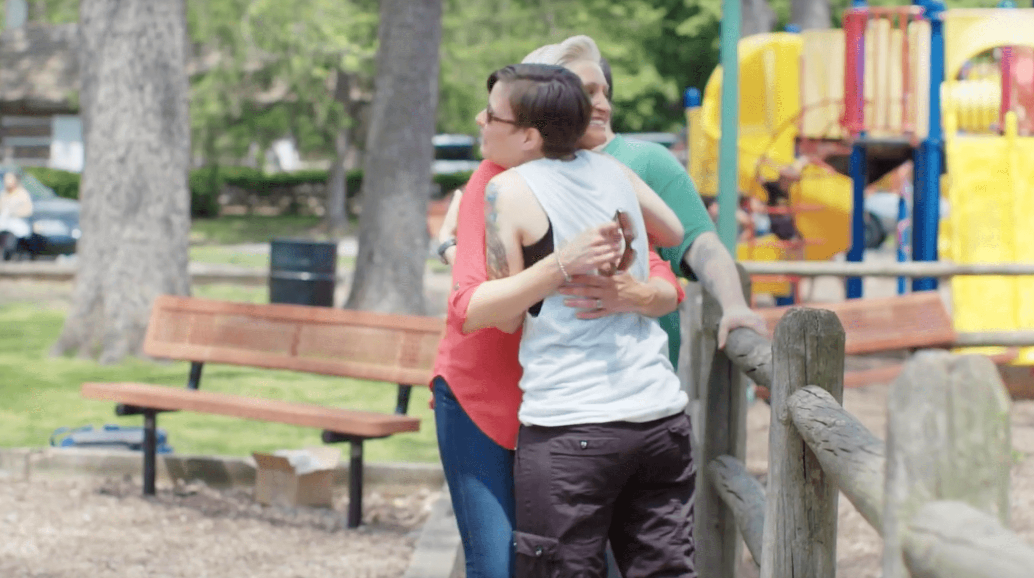 two women hugging at park